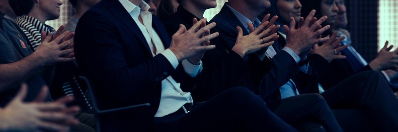 People in an audience folding hands