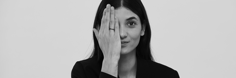 Woman covering her left eye with her hand