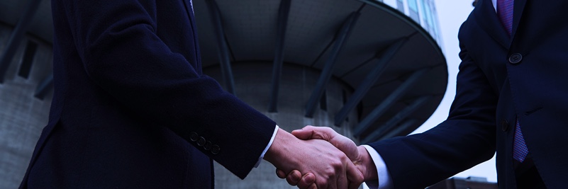 Two men in suits shaking hands